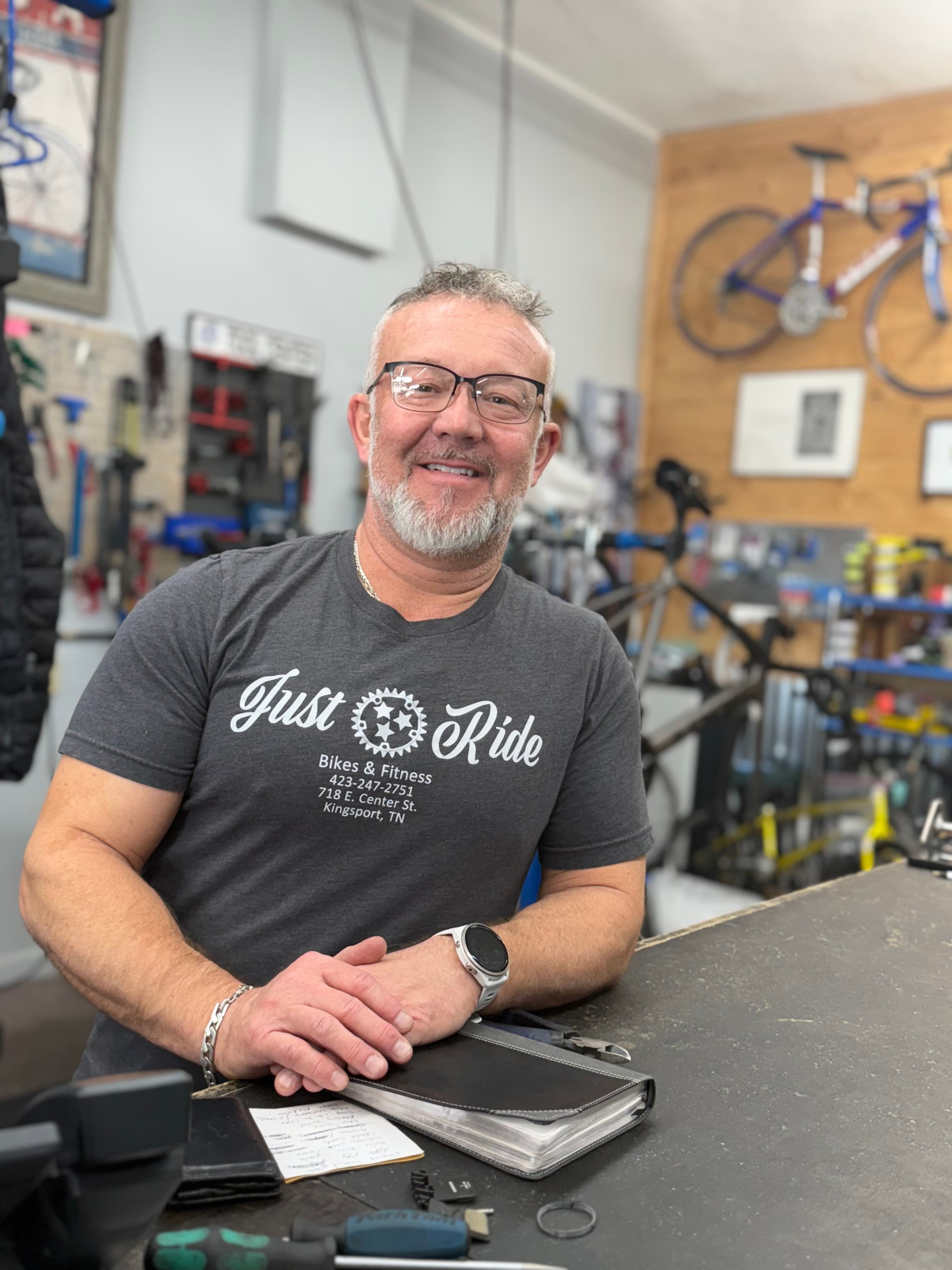 Brian, owner of Just Ride Bikes, at the front counter of the shop